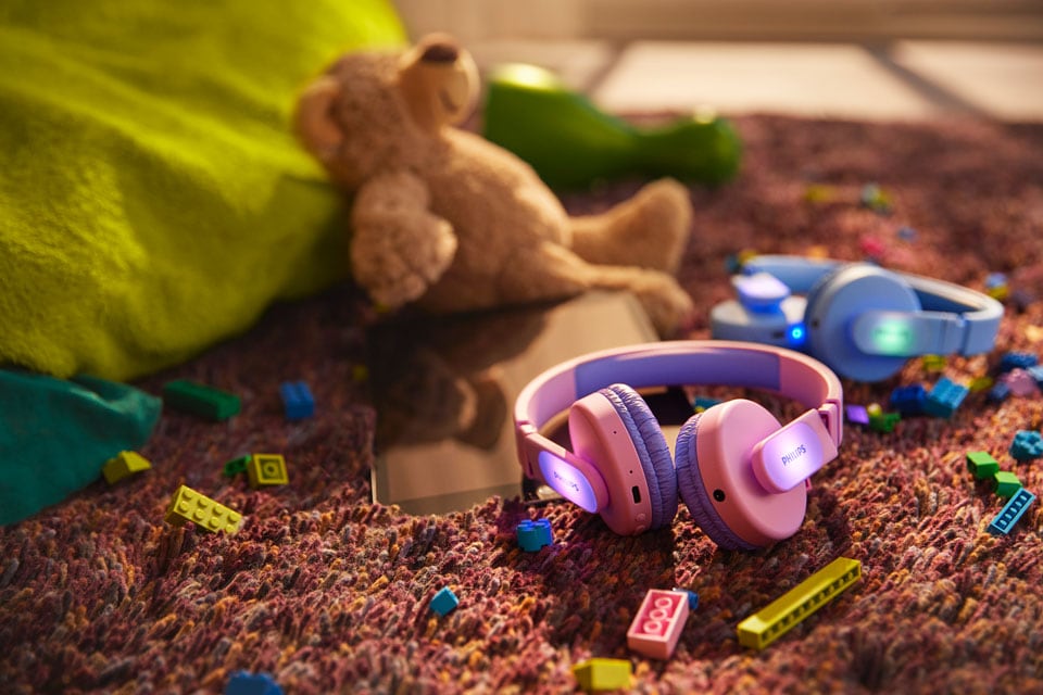 Modré a ružové detské slúchadlá na podlahe s hračkami