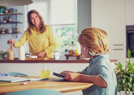 Chlapec sleduje video a používa detské otvorené bezdrôtové slúchadlá Philips