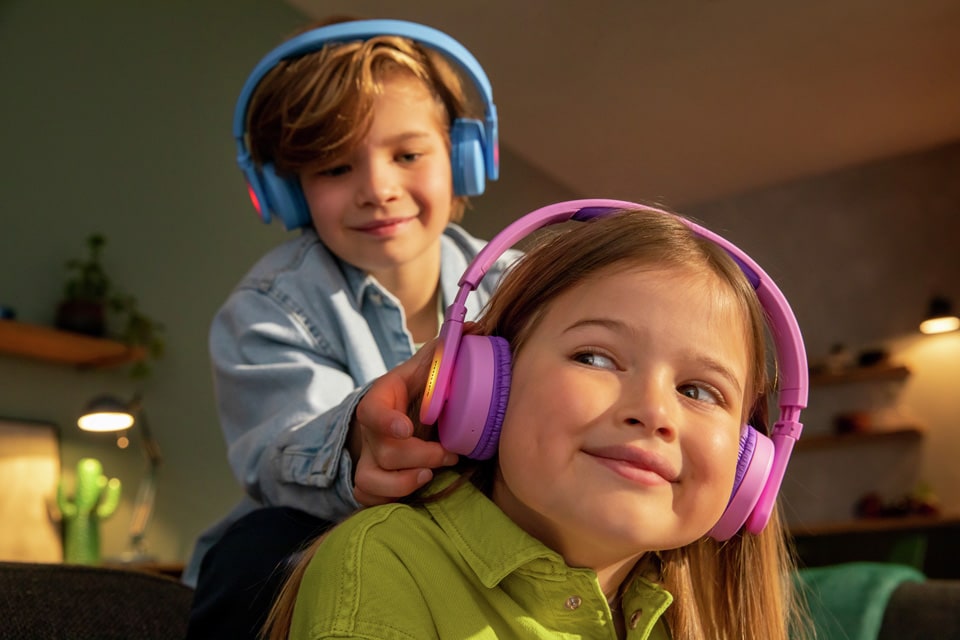 Dvaja súrodenci sa hrajú detských slúchadiel na ušiach